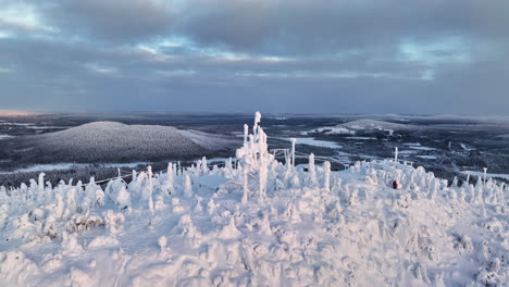 Aerial-view-around-a-snow-covered-radio-tower-in-Syote,-winter-evening-in-Finland