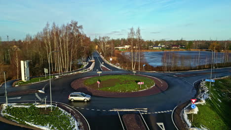 Top-down-static-shot-of-a-car-going-through-an-empty-roundabout