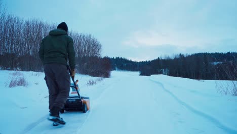 Man-Pushing-Snowblower,-Clearing-Snow-On-Roadside-In-Indre-Fosen,-Norway