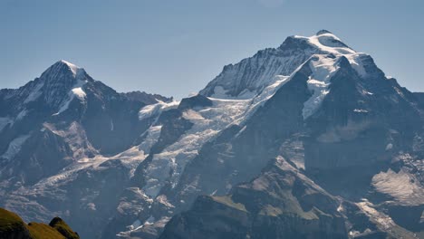 Telephoto-view-of-snow-and-ice-in-valley-ridges-of-stunning-rugged-alpine-mountain-on-sunny-day