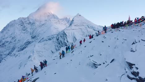 Group-of-hikers-ascending-snow-capped-peak-in-Himalayan-mountain-range