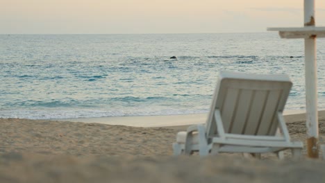 Summer-tropical-beach-scenery,-empty-plastic-chair-facing-ocean-in-Tenerife