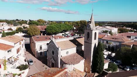 Aerial-rotating-view-over-small-town-Saint-Aunès-in-southern-France,-view-on-the-church