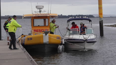 Australian-coast-guard-skillfully-docks-with-a-distressed-fishing-boat,-swiftly-securing-it-to-the-jetty