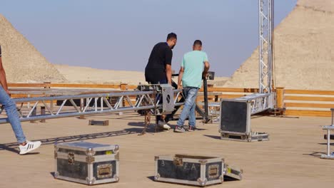 people-prepare-the-stage-for-a-party-in-the-desert-beside-the-Pyramids,-Giza-in-Egypt,-static-shot,-insert-shot