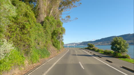 Dunedin,-New-Zealand---A-Scenic-Drive-Along-a-Lakeside-Highway-en-Route-to-the-Hilly-Landscapes-of-Otago-Peninsula---POV