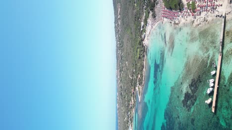 Beach-Parasols-and-blue-lagoon-at-La-Pelosa,-Sardinia