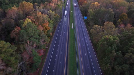 American-highway-at-dusk-surrounded-by-colorful-trees-in-autumn