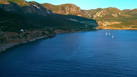 Cinematic-drone-shot-of-sailing-boats-at-Blue-Lagoon,-Masua-Beach,-Sardinia,-Italy