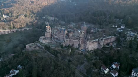 Majestätische-Luftaufnahme-Des-Historischen-Heidelberger-Schlosses-In-Deutschland,-Eingebettet-An-Einem-Mit-üppigen-Bäumen-Bedeckten-Berghang