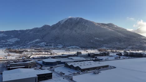 Montaña-Cubierta-De-Nieve-Cerca-De-La-Ciudad-Durante-La-Temporada-De-Invierno,-Dinámica-Aérea
