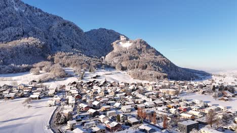 Casas-Cubiertas-De-Nieve-Cerca-De-La-Montaña-Durante-La-Temporada-De-Invierno,-Dinámica-Aérea