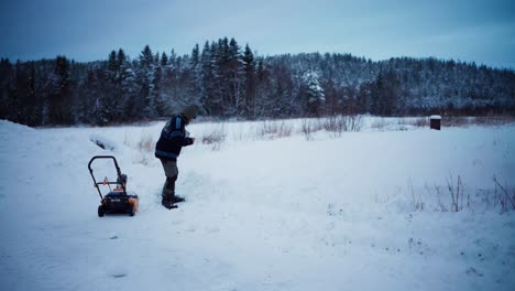 Person-Working-On-Winter-Landscape-With-Snow-Blower-And-Shovel
