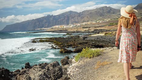 Sexy-adventurous-woman-walking-to-coastline-of-Tenerife,-back-view