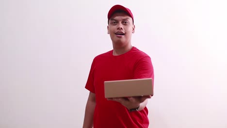 Young-asian-courier-man-holding-and-offering-cardboard