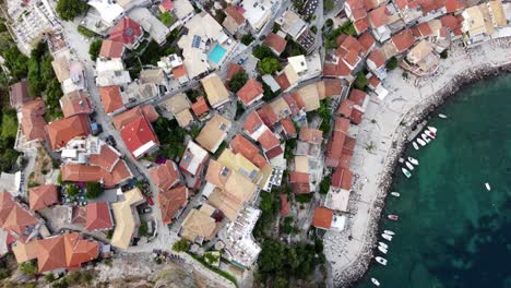 Overhead-drone-shot-of-Parga-seaside-town-traditional-houses,-Greece