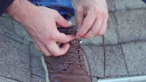 Closeup-of-Roof-worker-leg-foot-and-hands-tying-laces-on-his-work-boot