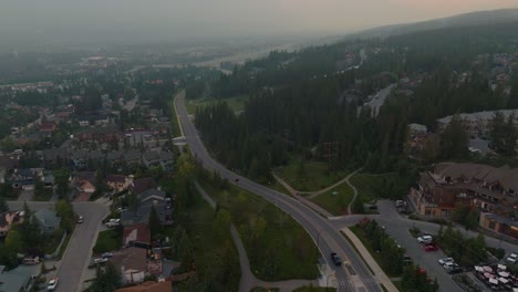 Drone-shot-looking-down-at-the-town-of-Canmore-Alberta-and-then-panning-up-to-reveal-that-the-Bow-Valley-is-covered-in-forest-fire-smoke-from-wildfires-in-British-Columbia