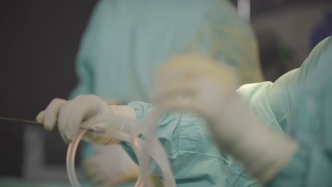 Cirujano-Plástico-Manipulando-Tubos-Durante-Una-Intervención-Estética,-Mostrando-Precisión-Y-Experiencia-En-Los-Complejos-Procedimientos-De-La-Cirugía-Estética.