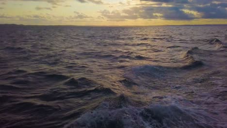View-of-the-deck-on-a-sea-trip,-cruise-waves,-backdrop-of-the-evening-sunset-in-the-sky