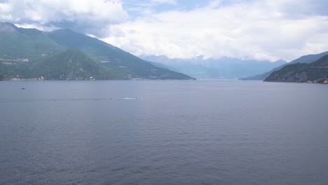 Speedboat-chasing-over-Lake-Como-surrounded-by-cloud-covered-mountains