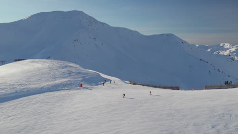 Saalbach-Hinterglemm-Ski-Resort-With-Skiers-In-Austria---Drone-Shot