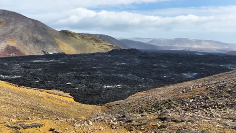 Massive-lava-field-in-Iceland-between-mountains,-pan-right-view