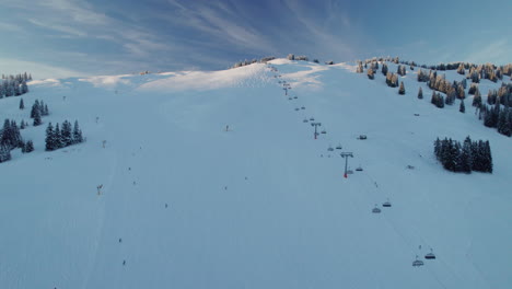 Ski-Lift-And-Skiers-On-The-Mountain-Ski-Resort-In-Saalbach-Hinterglemm,-Austria---Aerial-Drone-Shot
