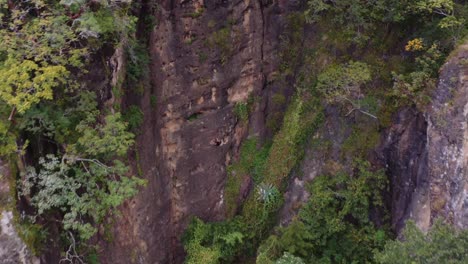 Drone-view-of-person-rappelling-down-cliff-face