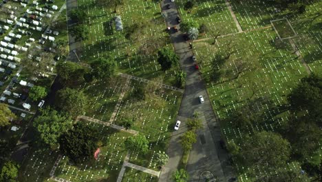 Drone-shot-of-cars-driving-in-cemetery