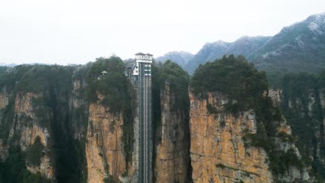 Toma-Aérea-Descendente-Que-Muestra-El-Famoso-Ascensor-De-Achique-En-El-Parque-Nacional-Zhangjiajie,-China