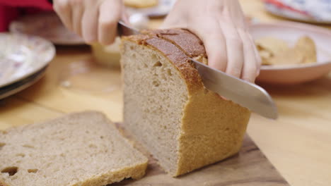 Cutting-a-slice-of-bread-using-a-sharp-breadknife-at-the-dinner-table