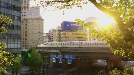 Toma-En-Cámara-Lenta-Mientras-El-Tren-Bala-Pasa-Por-El-Centro-Urbano-De-Tokio.