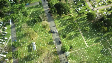 Drone-shot-of-cars-driving-in-a-cemetery