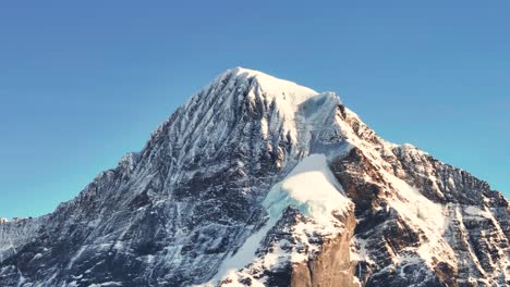 Majestuoso-Pico-De-Montaña-Escarpada-Cubierta-De-Nieve-Suiza-Durante-El-Día-Del-Cielo-Azul