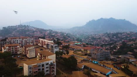 Aerial-view-over-apartment-buildings-in-the-suburbs-of-hazy-Yaounde,-Cameroon