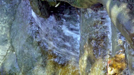 A-natural-stream-flows-over-a-rocky-surface
