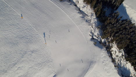 Zona-De-Esquí-Con-Gente-Esquiando-En-Saalbach-hinterglemm,-Austria---Antena-De-Arriba-Hacia-Abajo