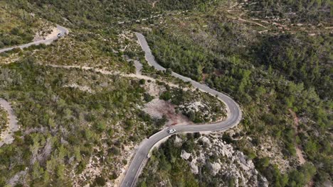 Drone-shot-of-driving-car-on-the-road-in-the-Esporles-valley-on-the-island-village-of-Mallorca-in-the-Serra-de-Tramuntana,-Spain