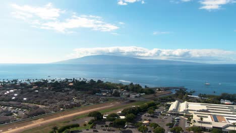 Lahaina-township-and-island-with-clouds-above-in-horizon,-aerial-descend-view
