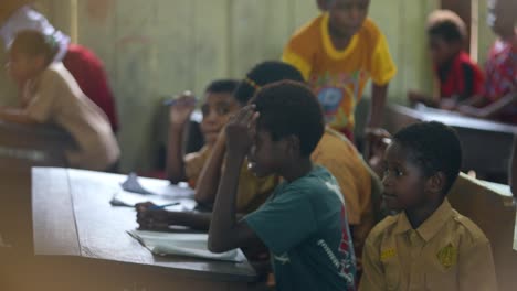 Kinder-Lernen-Im-Klassenzimmer-Vor-Dem-Tisch,-Es-Gibt-Bücher-Zum-Schreiben,-Dies-Ist-Eine-Grundschule-In-Papua,-Indonesien