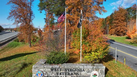 West-Virginia-Veterans-Memorial-Freeway-stone-sign-with-American-and-POW-MIA-flags-against-colorful-fall-foliage-background