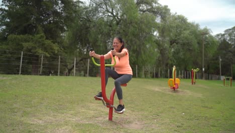 The-Woman-is-Utilizing-a-Pedal-Exercise-Equipment-in-the-Park---Wide-Shot