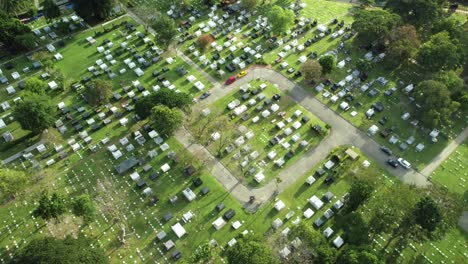 Drone-shot-of-Memorial-Cemetery-with-Car-driving-by-in-The-Philippines