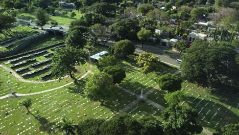 Drone-shot-of-Memorial-cemetery-with-trees-and-cars-in-the-Philippines