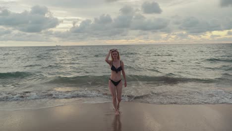 Young-blond-attractive-woman-walking-from-the-ocean-over-the-beach