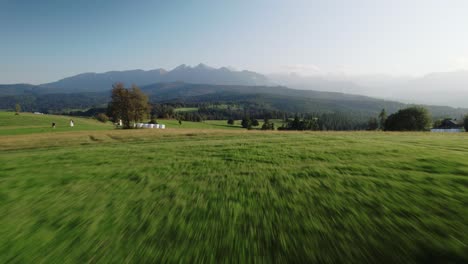4k-Bird-Eye-View-of-High-Tatra-Mountains,-Green-Fields-and-Trees-on-Sunny-Day
