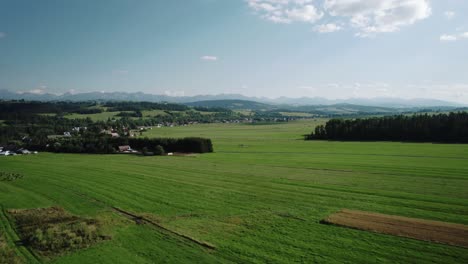 4k-Aerial-Shot-of-Tatra-Mountains,-Green-Fields-and-Countryside-on-Sunny-Day