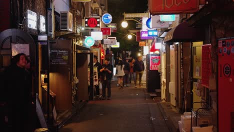 Slow-motion-tilt-reveal-of-popular-bar-street-in-Tokyo-with-hundreds-of-drinking-establishments,-early-evening-in-shijuku-golden-gai