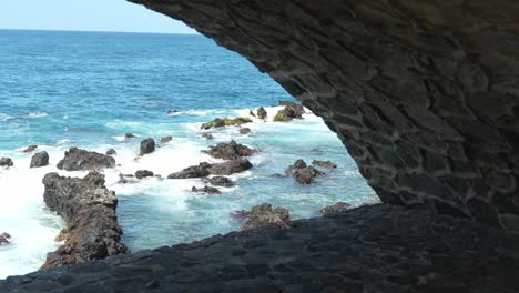 View-of-ocean-coastline-from-inside-cave,-slow-motion